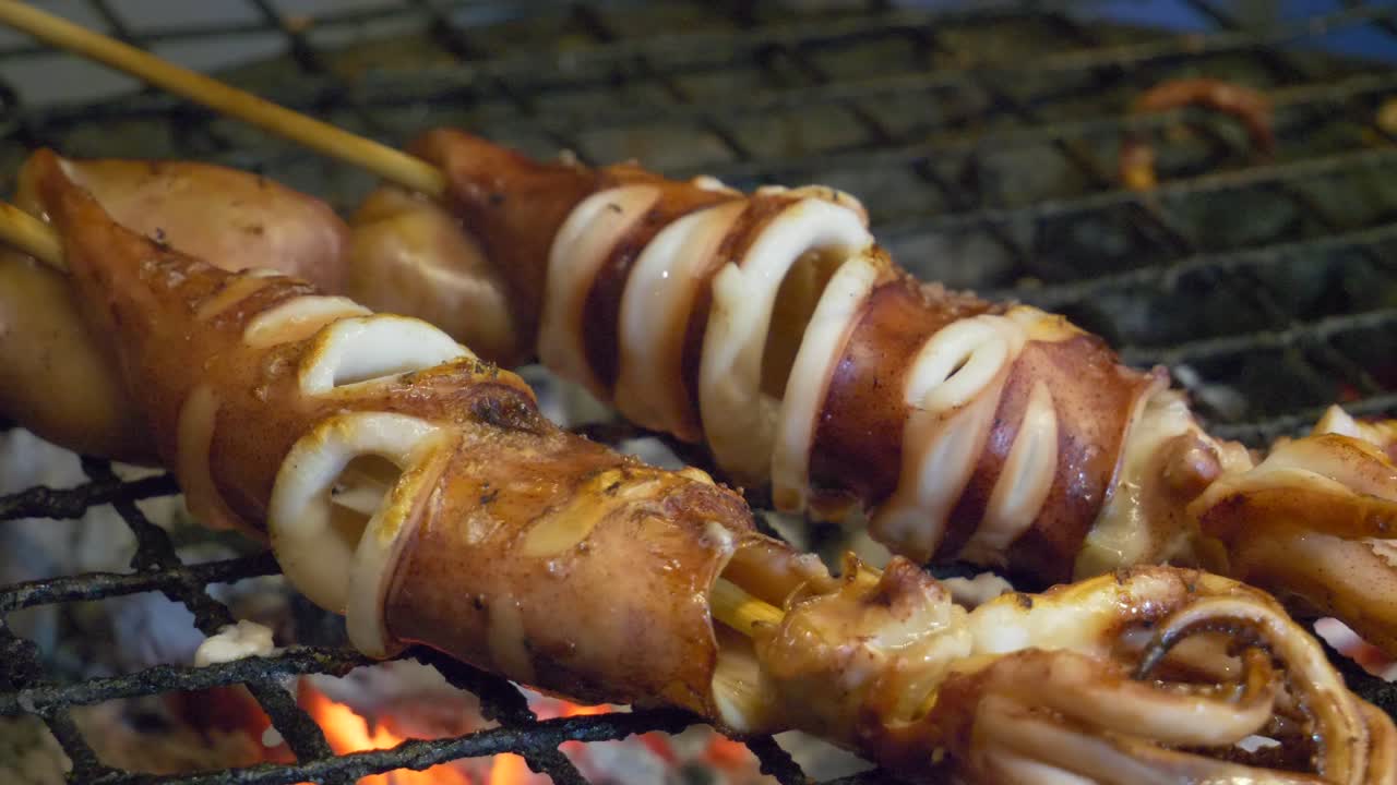 mercado nocturno de tailandia puesto de comida calamar en parrilla cocido jugoso en carbón caliente