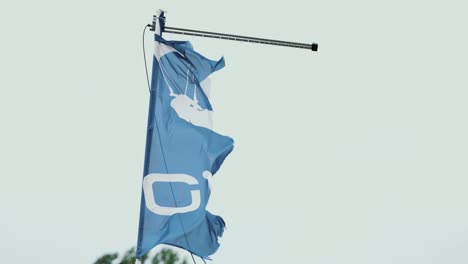 close up of torn light blue flag blown by the wind during storm