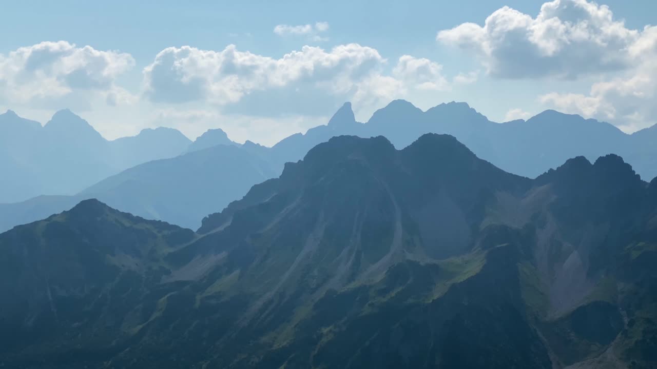 オーストリアのカンツェルヴァントにあるヴィアフェラータから、白い雲が浮かぶアルプスの山々のパノラマビュー。