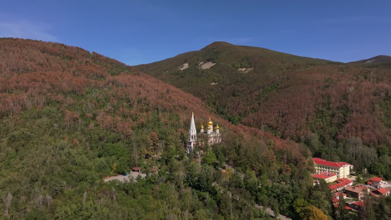 Shipka-kyrkans gyllene kupoler lyser i höstskogen, Bulgarien.