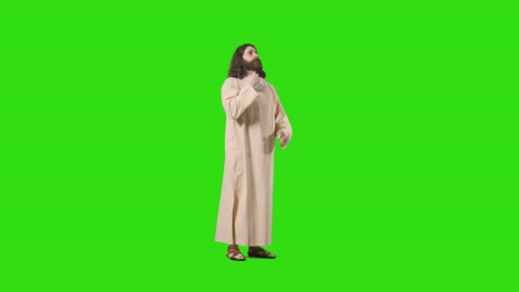 tomada de estudio de un hombre vestido con túnicas y sandalias con pelo largo y barba que representa la figura de jesucristo orando en la pantalla verde 2