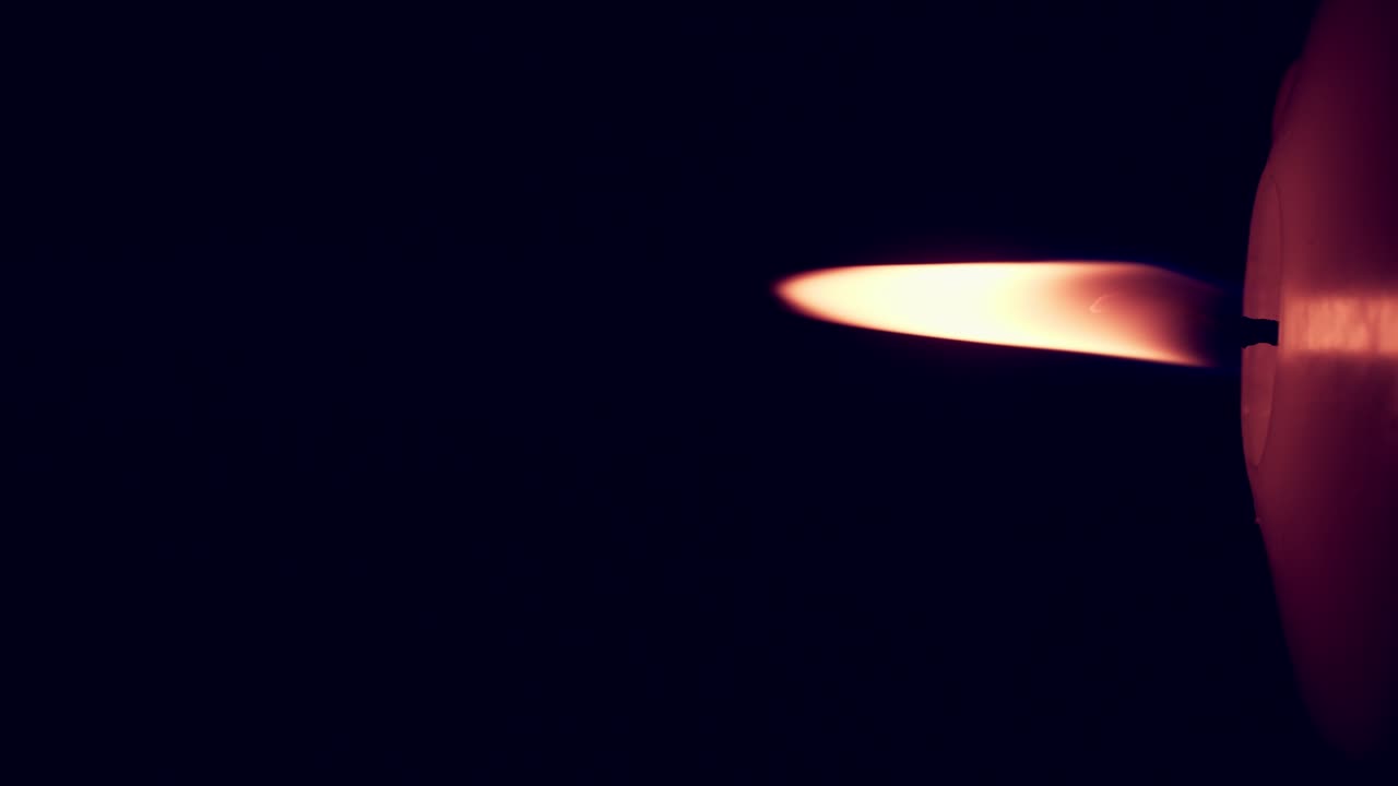 rotación vertical de las luces de llama de una sola vela amarilla grande aisladas en un fondo negro