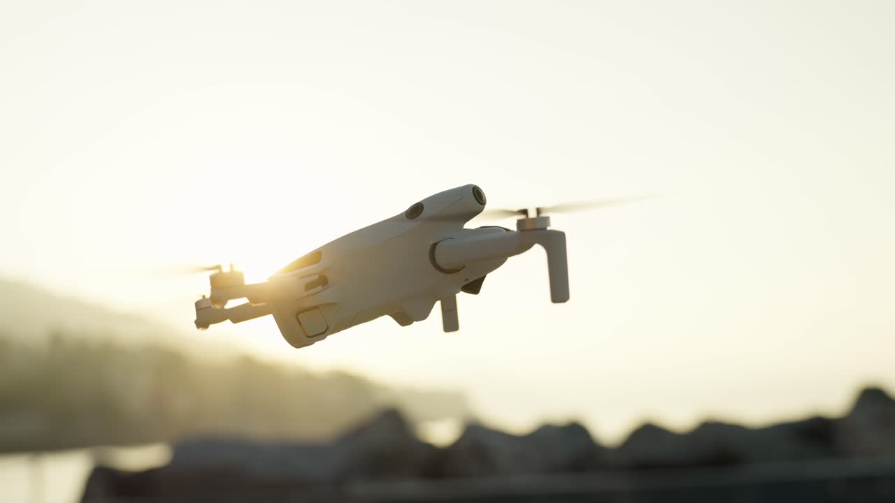 Drone flying at sunrise over a rocky landscape with sunlight illuminating the scene