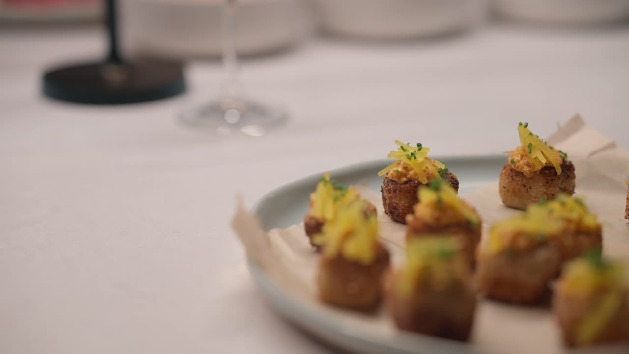 Un bocconcino di tofu fritto viene posizionato su un piatto e preparato per il servizio (slow motion 4K)