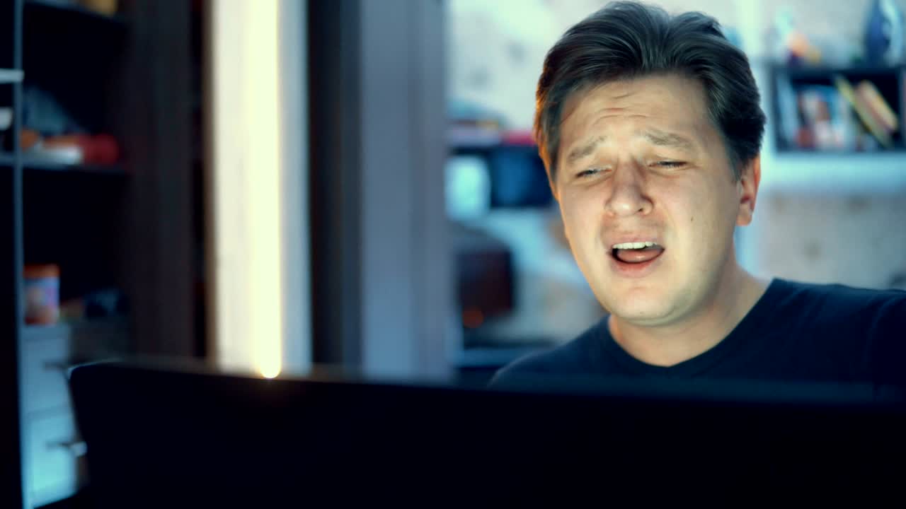 한 남자가 노트북으로 일하고 노래하고 있습니다.