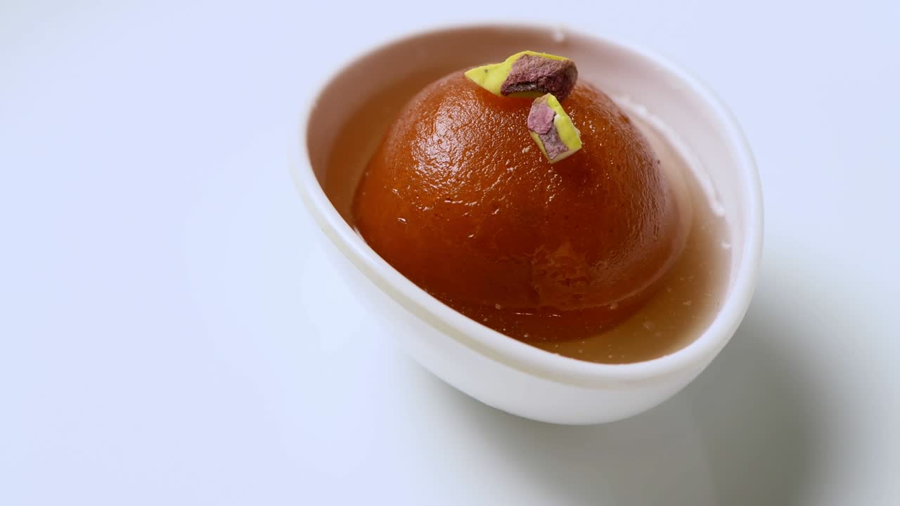 Gulab jamun rotante con granella di pistacchio (dolce indiano) | Dessert