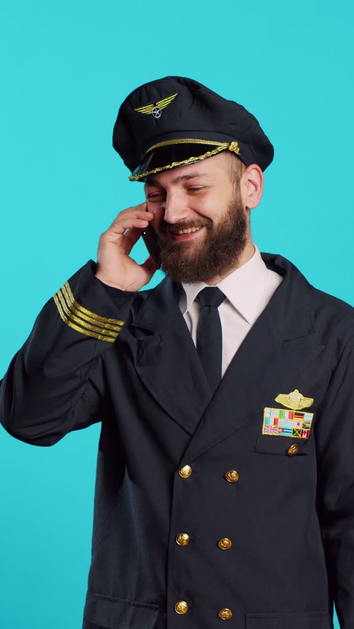 Video verticale: aviatore che parla al telefono con lo smartphone e ride