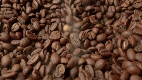 close up of seeds of coffee. fragrant coffee beans are roasted smoke comes from coffee beans.