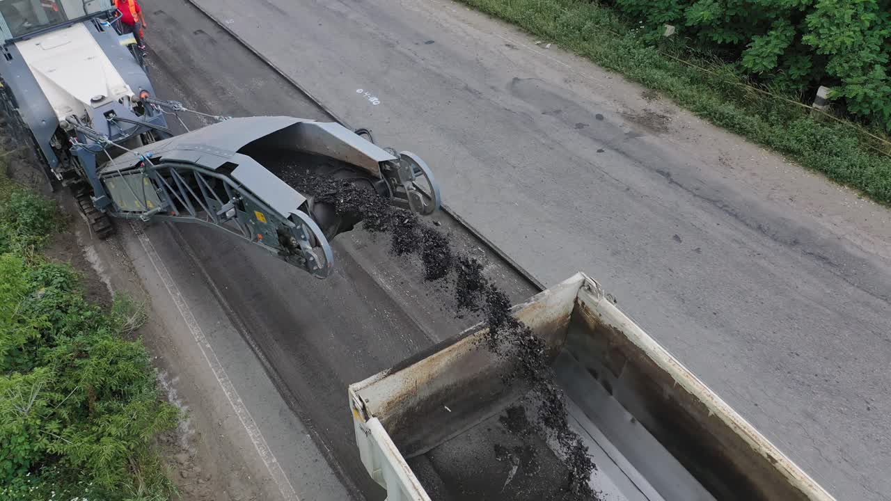 Laying new asphalt on the road. Drone flies over a construction site with workers and machines