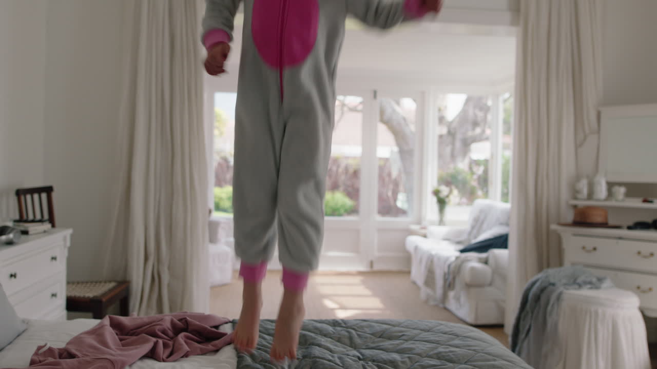 niña feliz bailando en la cama divirtiéndose niño de humor lúdico disfrutando de la mañana de fin de semana en casa