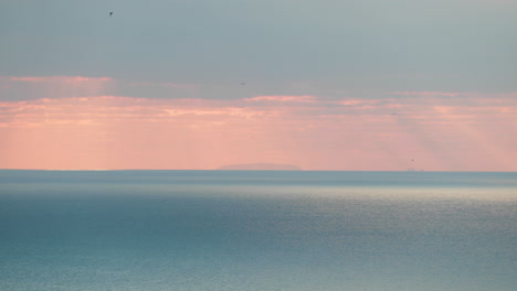 sunset over the calm blue waves of nazare, portugal -wide