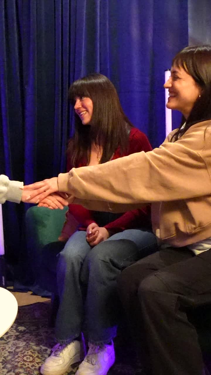 Gruppo di amici che si stringono la mano e sorridono in uno studio di podcast
