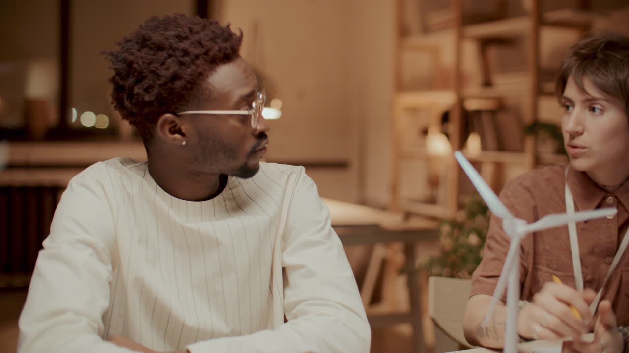 equipo de jóvenes ingenieros discutiendo soluciones de energía sostenible en la oficina
