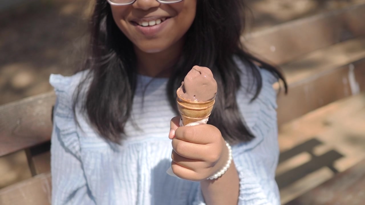 Menina Saboreando Casquinha de Sorvete de Chocolate no Parque