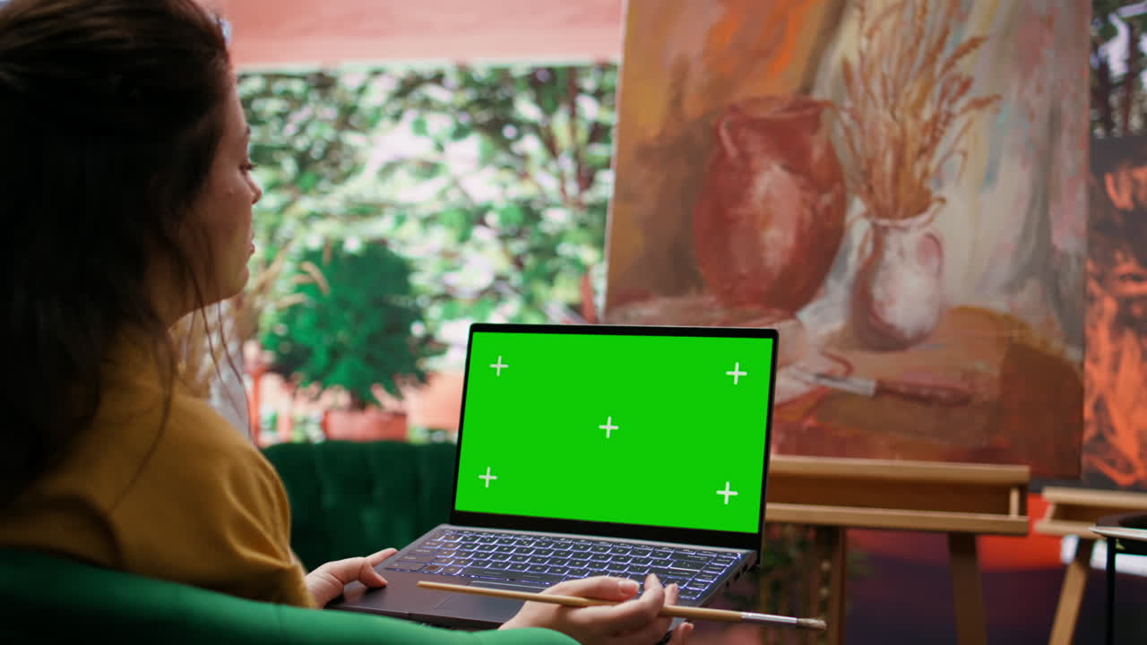 Artist painting with a laptop with chroma key screen