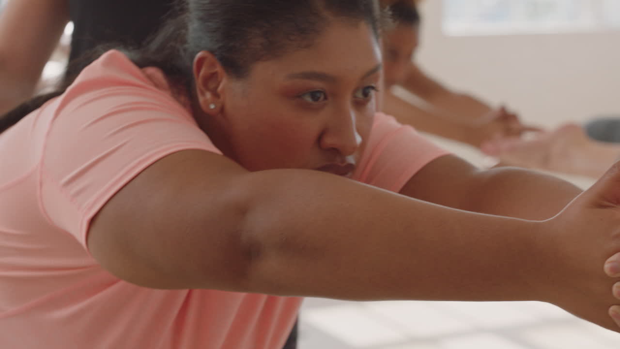 instructor de clase de yoga enseñando pose de guerrero a una joven con sobrepeso haciendo ejercicio disfrutando de un estilo de vida saludable en el gimnasio practicando postura