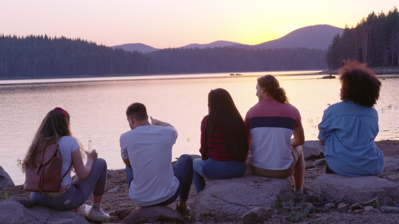 amigos disfrutando de la puesta de sol junto al lago.