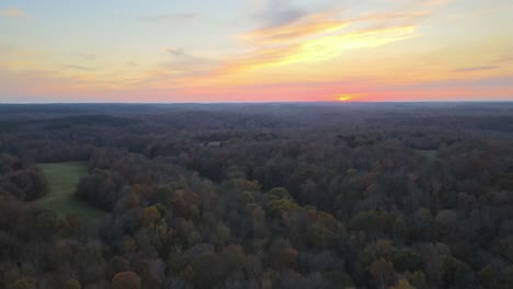 flying away from a fiery red sunset and a beautiful autumn countryside