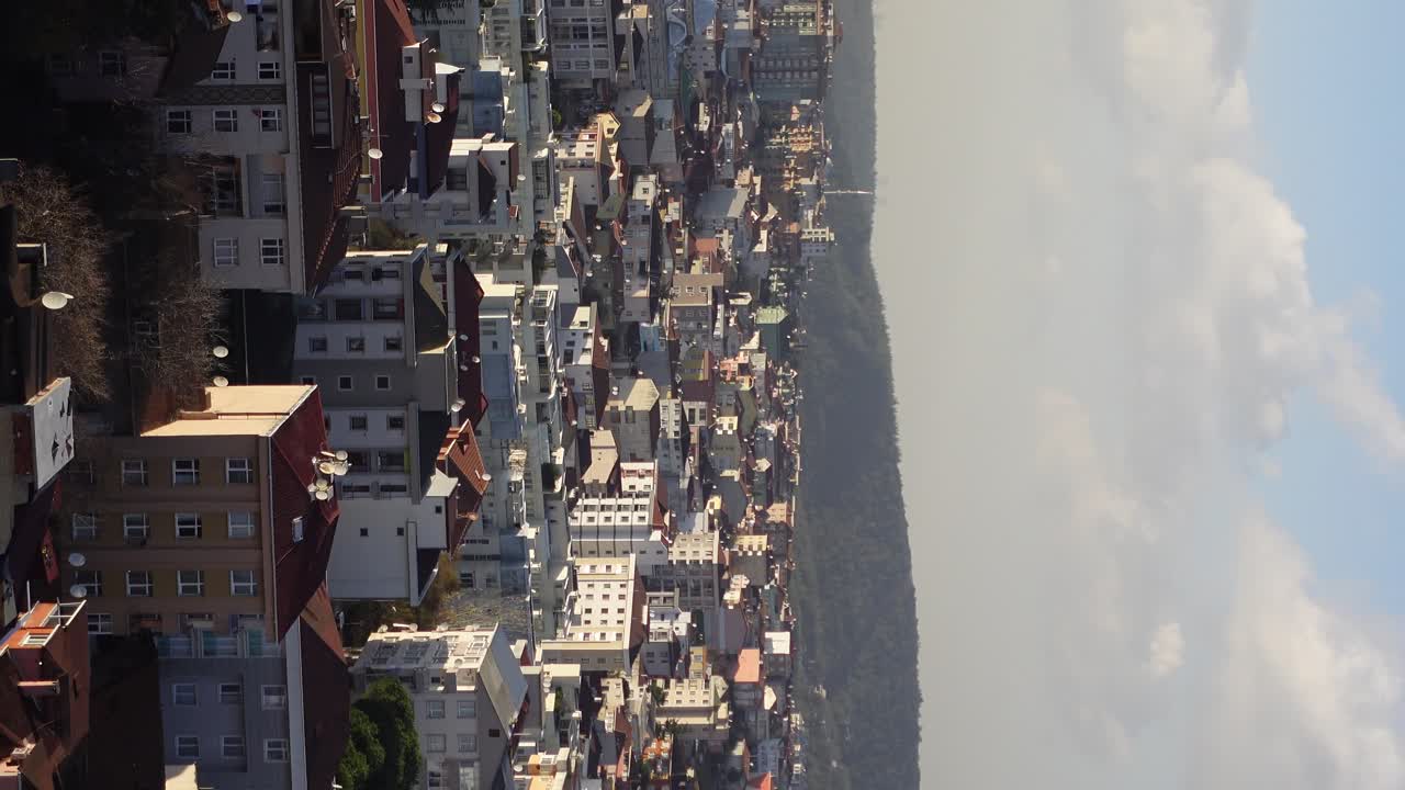 Cityscape Aerial View with Mountains and Clouds