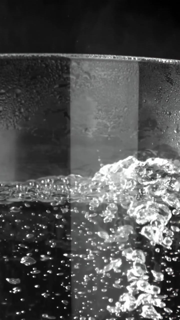 Primo piano monocromatico di acqua bollente con bolle in risalita