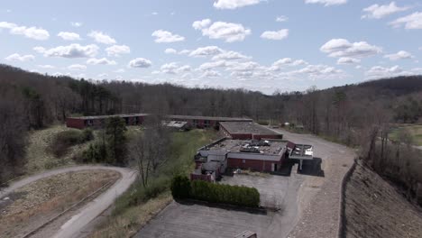 aerial drone footage dollying forward over a creepy abandoned hotel on top of a hill