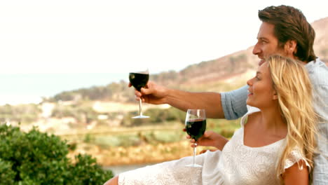 couple looking far away with red wineglasses in slow motion