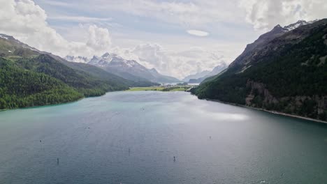 popular watersports location silvaplanersee, kitesurfers riding the lake