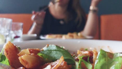 young attractive girl eating delicious dinner in restaurant