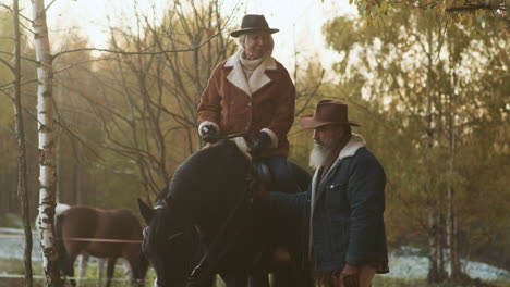 une femme assise sur un cheval près des bois.