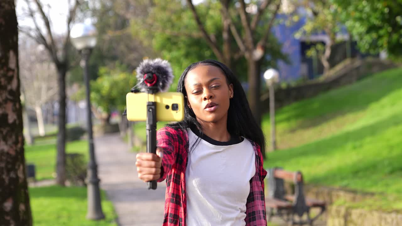 Donna che fa video blog in un parco