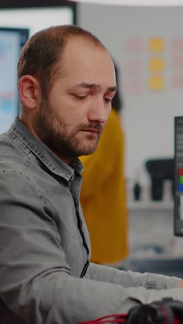 vertical video videographer looking at camera smiling working in creative startup workplace