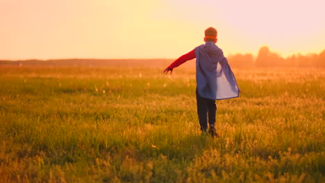 Un-Niño-Disfrazado-De-Superhéroe-Al-Atardecer-Corre-Por-El-Campo-Riendo-Y-Sonriendo.