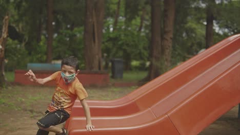 Ein-Kleiner-Junge-Freut-Sich,-Wenn-Er-Auf-Dem-Kinderspielplatz-Eine-Rutsche-Hinunterrutscht