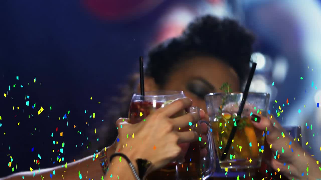 Confetti colorati che cadono su un gruppo di amici che brindano in un bar