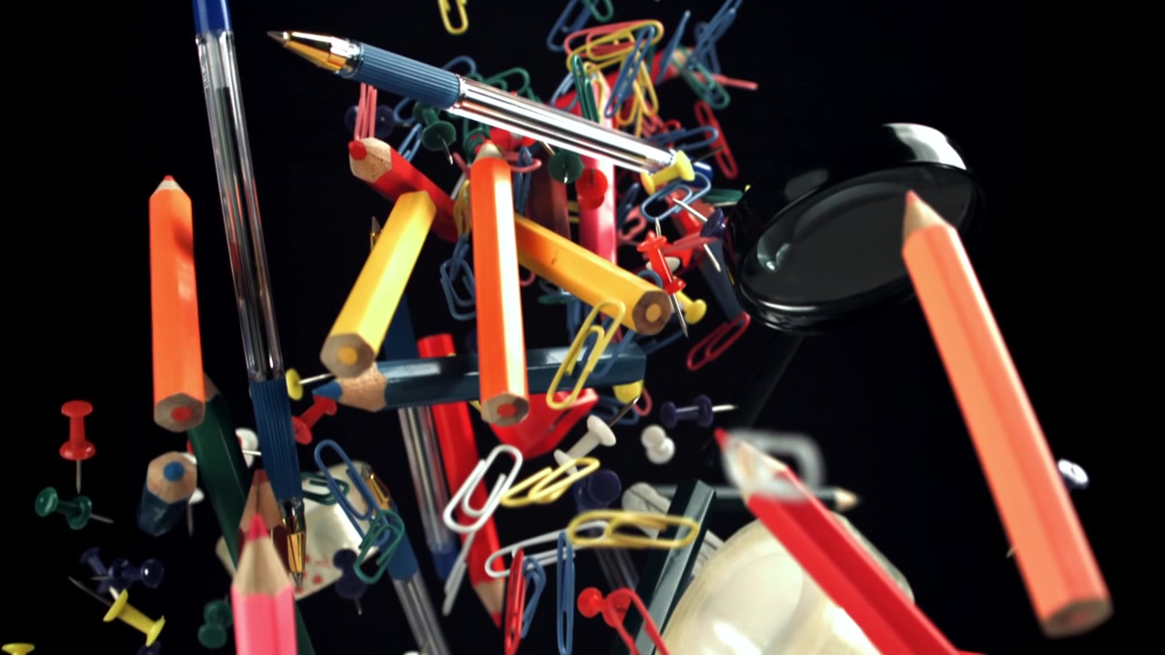 Assortment of Colorful School and Office Supplies Floating on Black