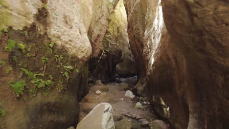 Drone-Shot-of-a-narrow-Canyon-surrounded-by-big-rocks