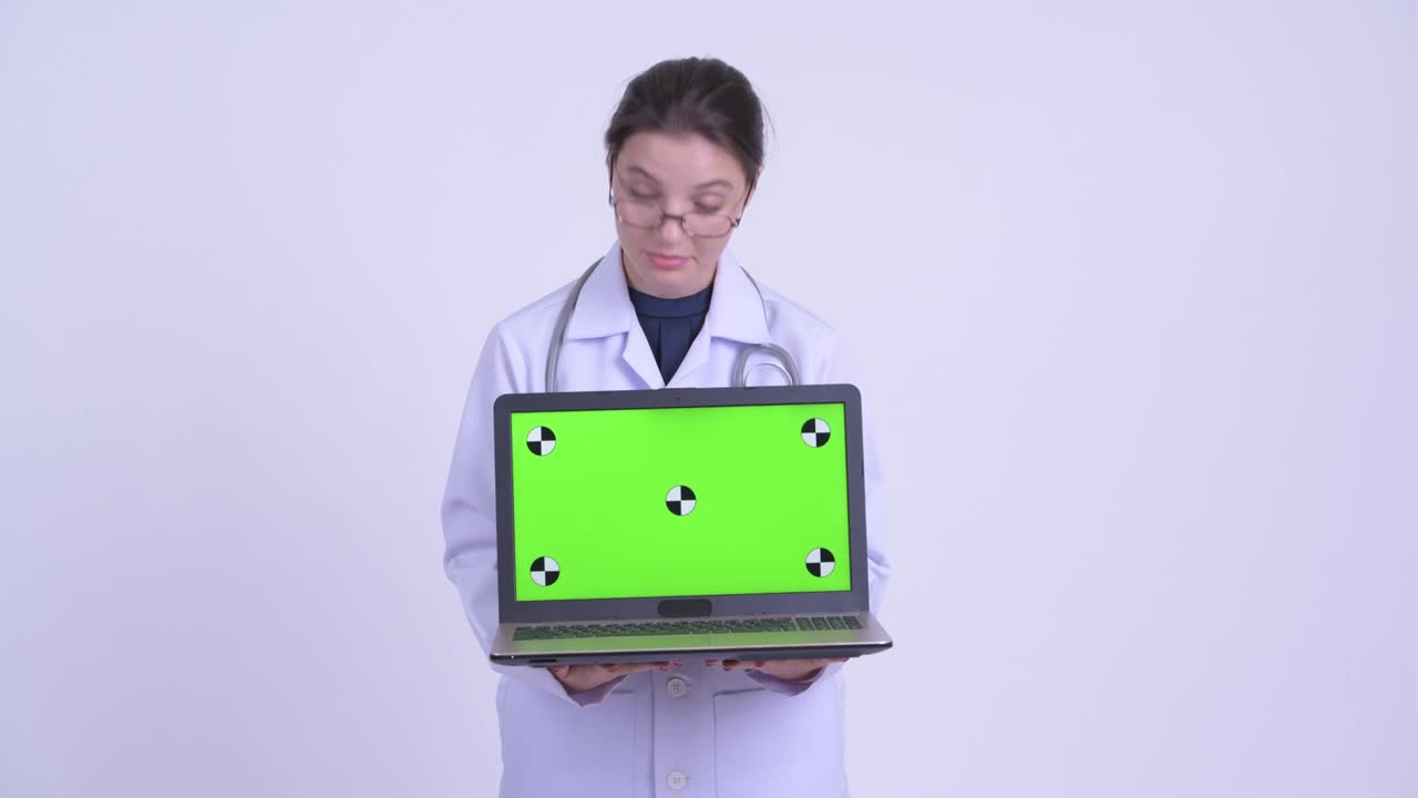 feliz joven hermosa mujer médico con computadora portátil