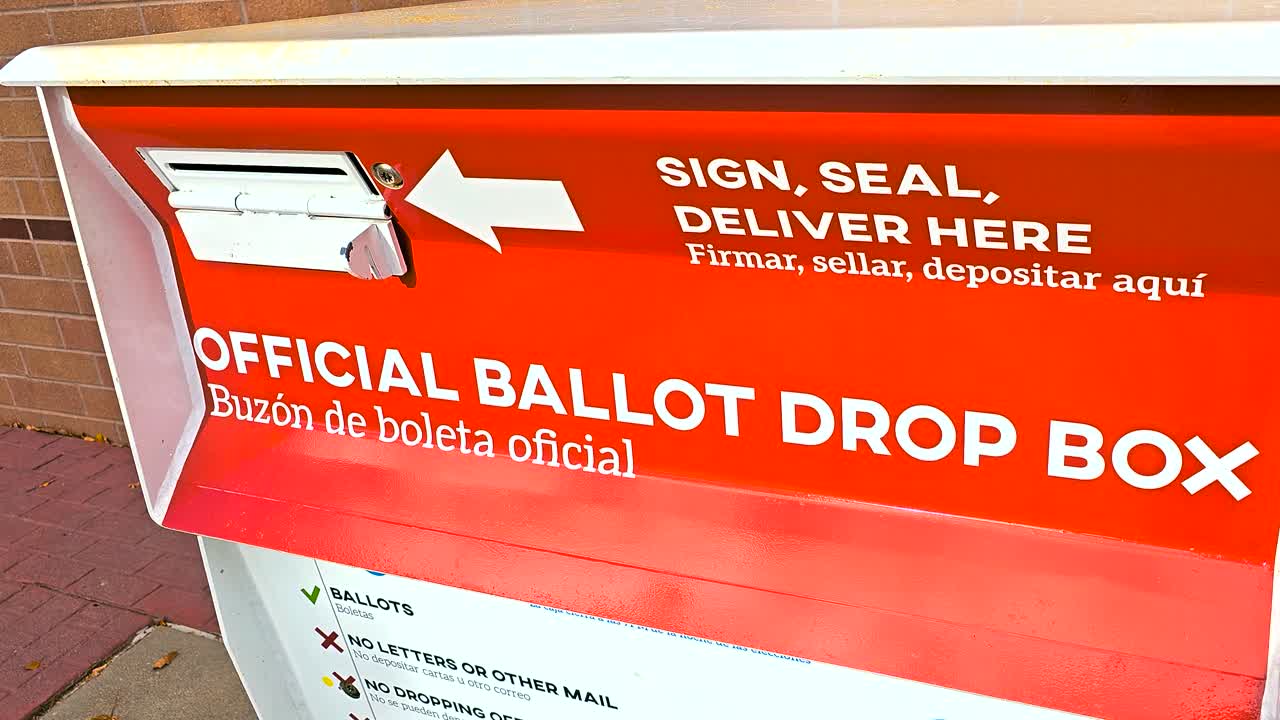 A sturdy outdoor metal ballot drop box marked “Official Ballot Drop Box” with Spanish “Buzón de Boleta Oficial,” serving as a secure option for voters to return their completed mail-in ballots