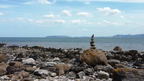 espiritualidad equilibrada meditación guijarros apilados en alienígena cordillera rocosa playa costa derecha paralaje