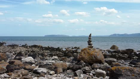 balanced spirituality meditation pebbles piled on alien rocky mountain range beach coastline right parallax