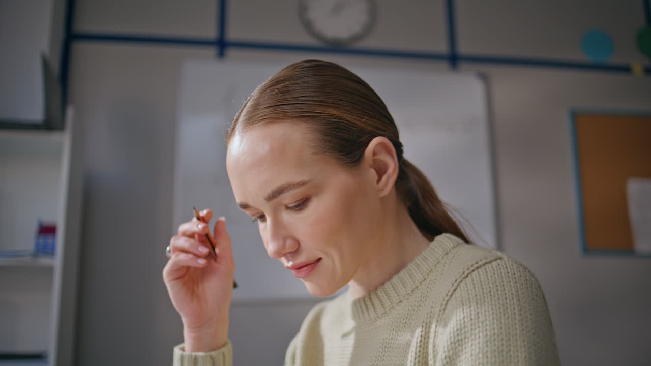 Smiling lady working classroom alone closeup. Woman teacher checking homework