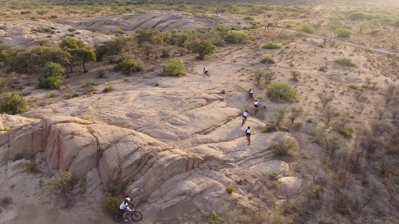 drone disparó siguiendo a las personas ciclistas golpeando una curva en una carrera de bicicletas en las montañas del desierto