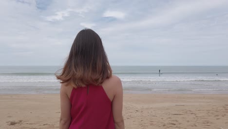 Junge-Asiatische-Frau-Trägt-Rotes-Kleid-Und-Geht-Entspannt-Am-Strand-In-Den-Sommerferien-In-Slowmotion