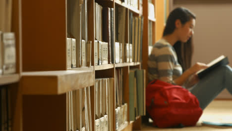 student reading a book in the library