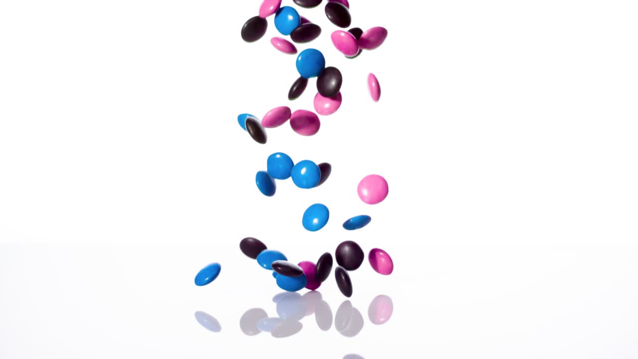 색 배경에 떨어지는 사탕 초콜릿, 느린 동작, 1000fps.