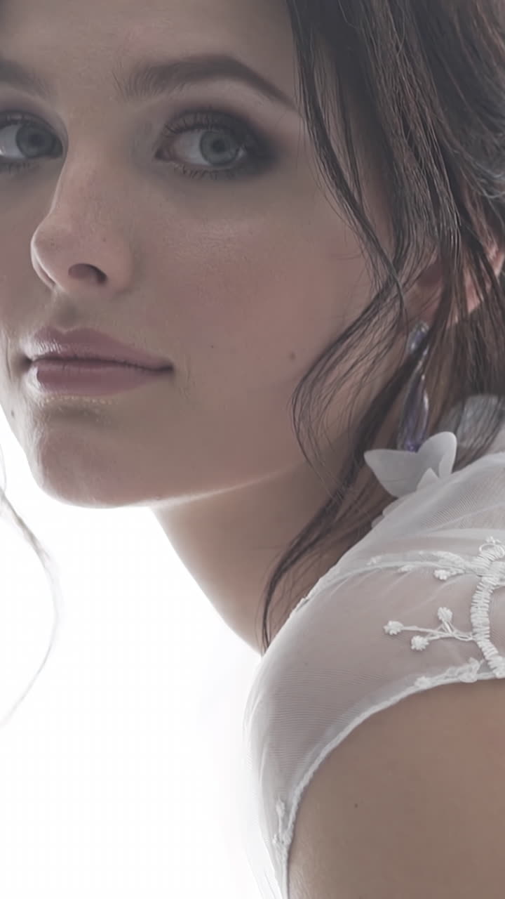 Ritratto al rallentatore di una splendida giovane donna bruna con occhi grigi, in vestaglia trasparente di pizzo.
