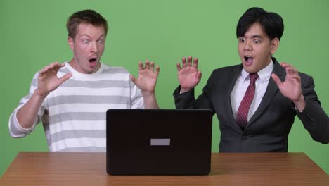 young asian businessman and young scandinavian businessman working together with laptop