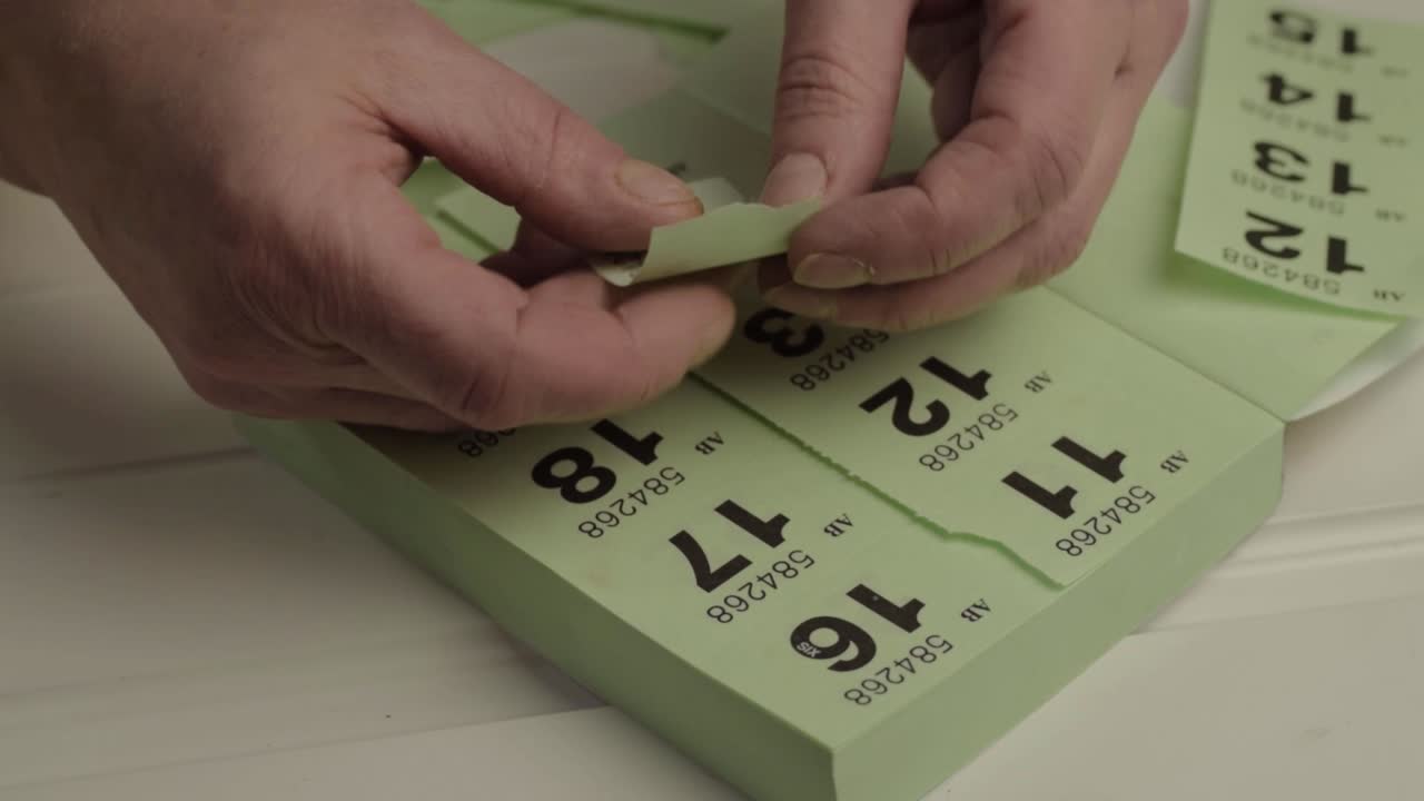 Hands folding lottery tickets close up shot