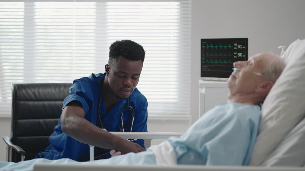 Premium stock video - A black cardiologist doctor is talking to a 60-70 ...
