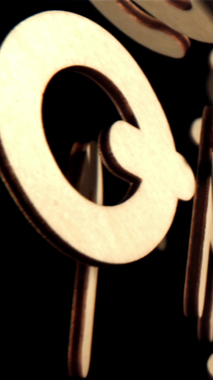 Lettere e numeri di legno che ruotano per formare un messaggio su sfondo nero
